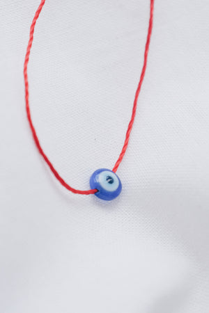 Evil eye pendant necklace on red string, symbolizing protection and warding off negative energy.