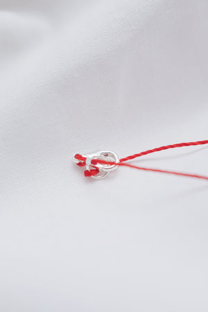 Evil eye pendant necklace on red string, symbolizing protection and warding off negative energy.